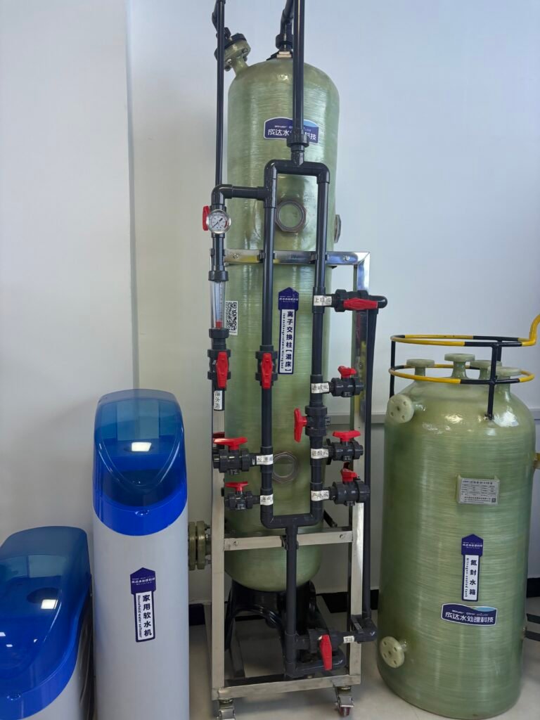 This picture shows a mixed-bed ion exchange column device used for industrial water treatment. The main body is a large, light green cylindrical container, usually made of corrosion-resistant fiberglass reinforced plastic (FRP) and supported by metal brackets. The core feature of the equipment lies in its complex and orderly piping system. Multiple black PVC pipes are connected to the top, bottom and sides of the column through several prominent red manual valves, precisely controlling the water flow, resin regeneration and chemical agent addition processes. Pressure gauges are also installed on the side of the column for real-time monitoring. Against a pure white background, the equipment structure is clear and prominent. The light green container, black pipes and red valves form a striking visual contrast. The overall design presents a modular and standardized industrial style, specifically providing deep deionization purification for industries such as electroplating, pharmaceuticals, and microelectronics that require ultra-pure water.
